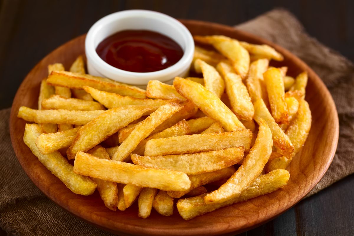 Picture of french fries on a plate with dip sauce.