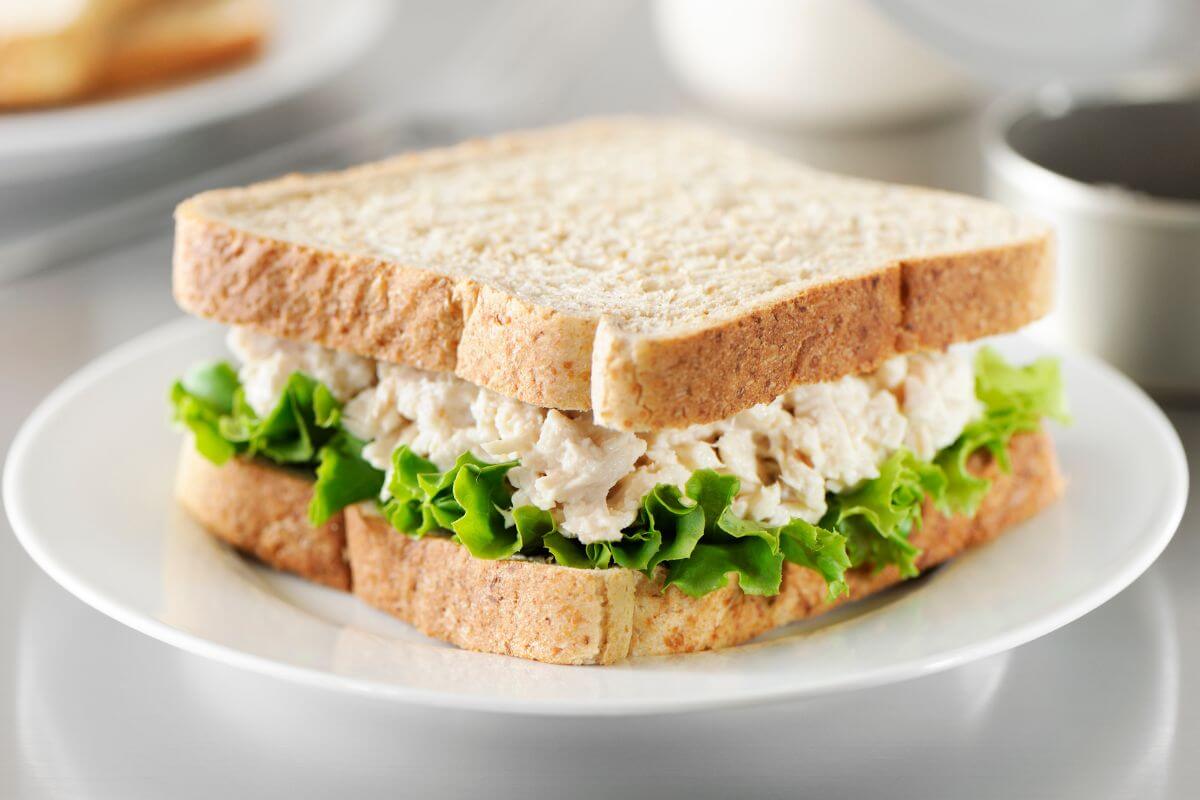 The picture of a plate with a tuna salad sandwich which perfect for lunch or dinner when you're trying to save money.