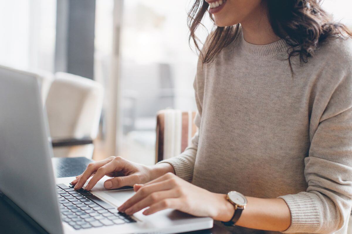 The picture of a girl typing on a laptop indicates that finding more cheap foods when broke helps you save money without sacrificing flavor.