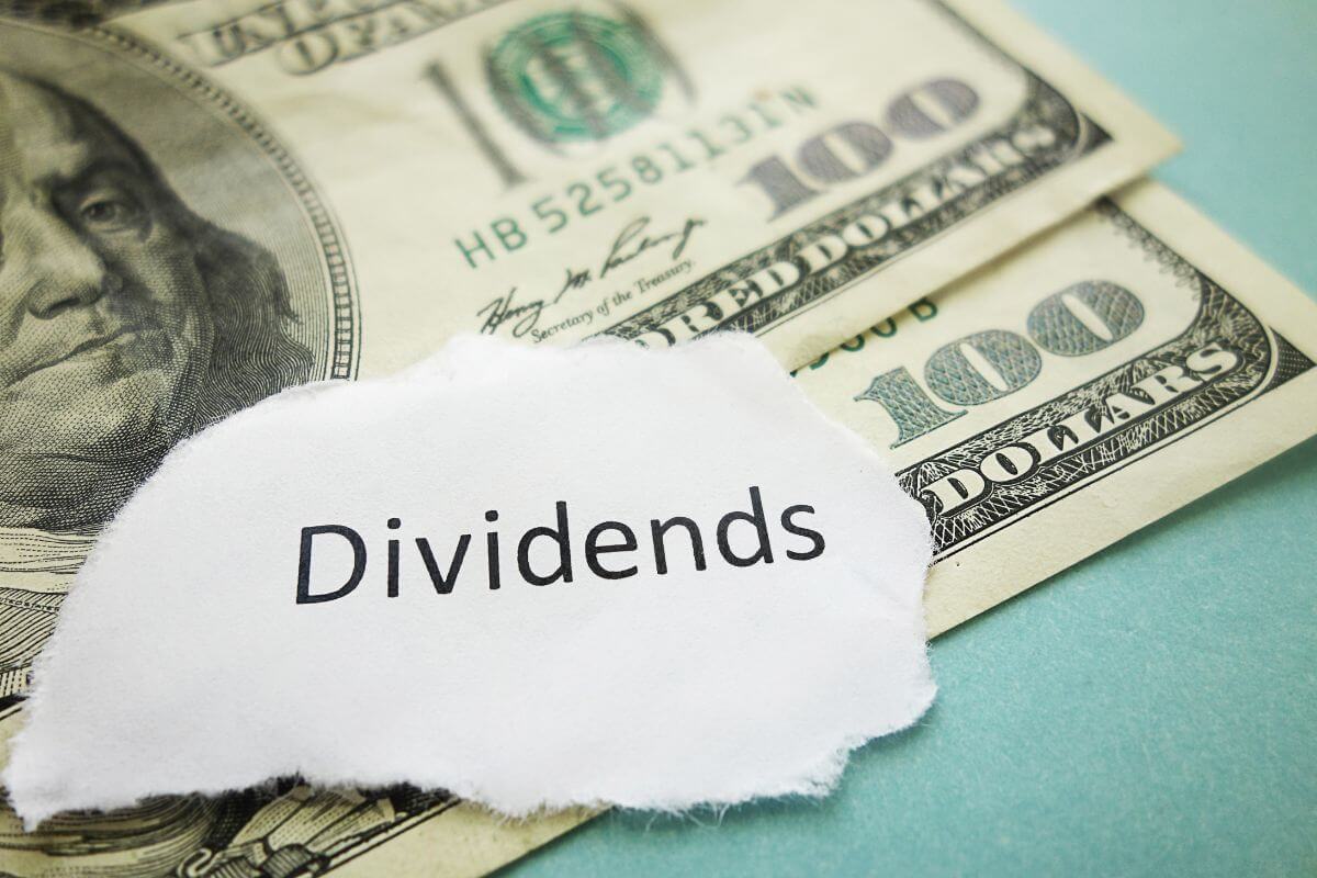 The picture of dollar bills and a piece of paper with a note indicating earning through dividends and capital gains allow for steady income and portfolio growth over time.