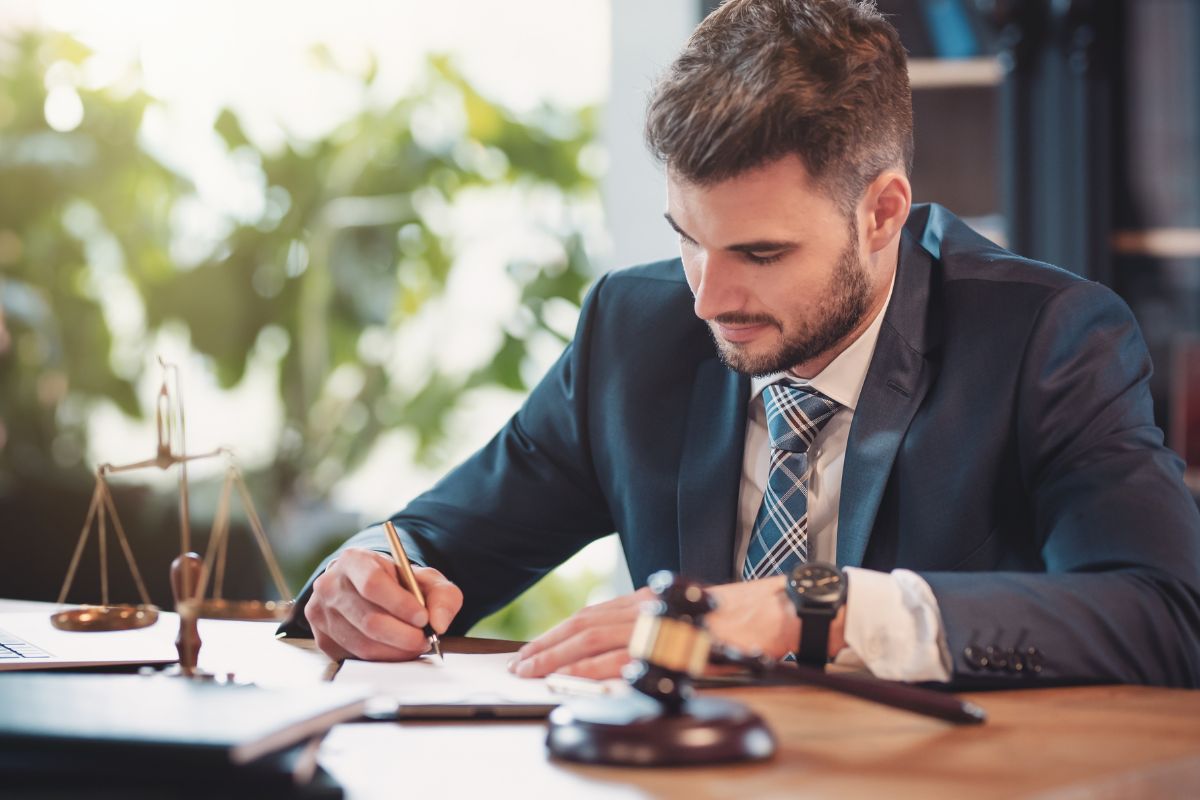 Picture of a lawyer signing a paper.