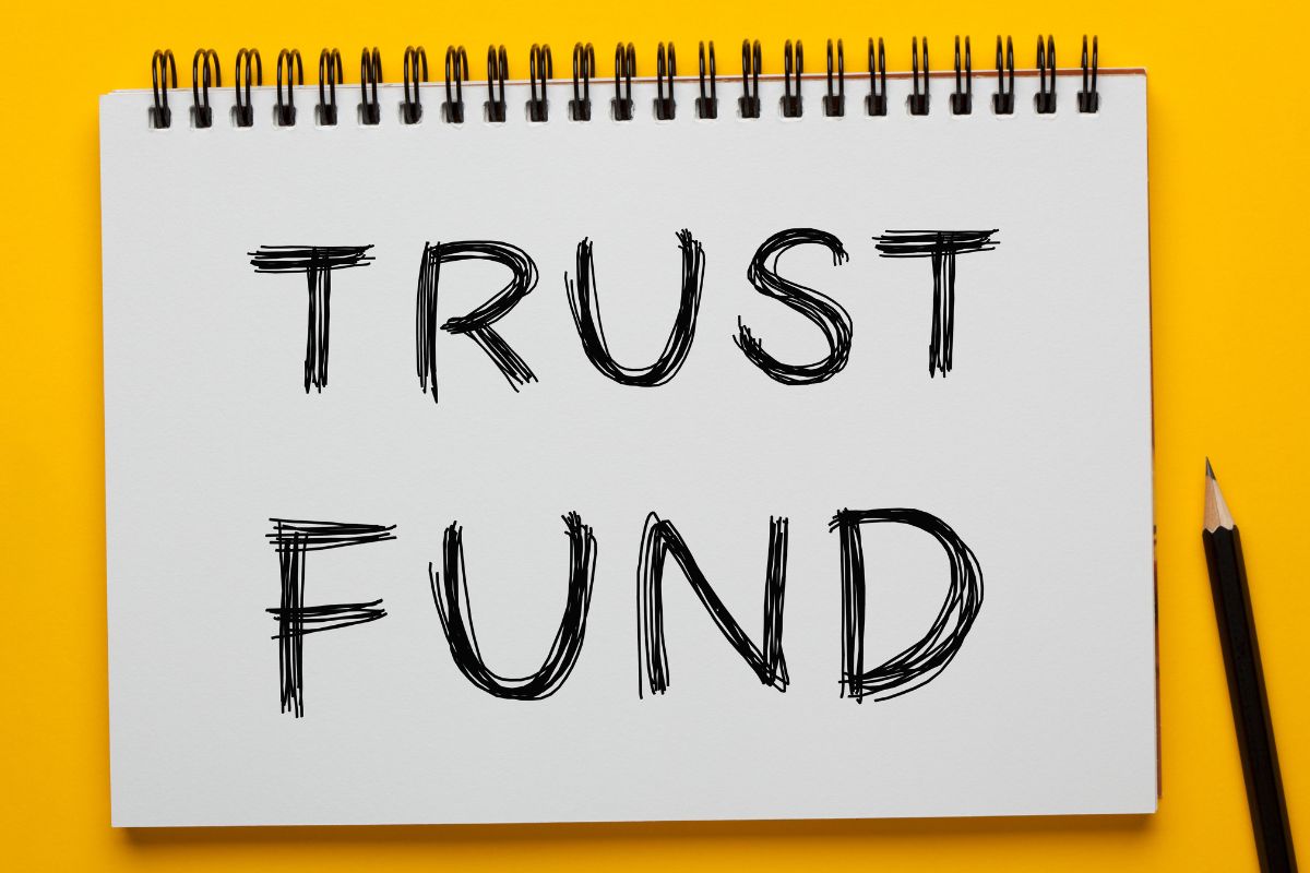 Photo of a pen and a notebook with trust fund wording.