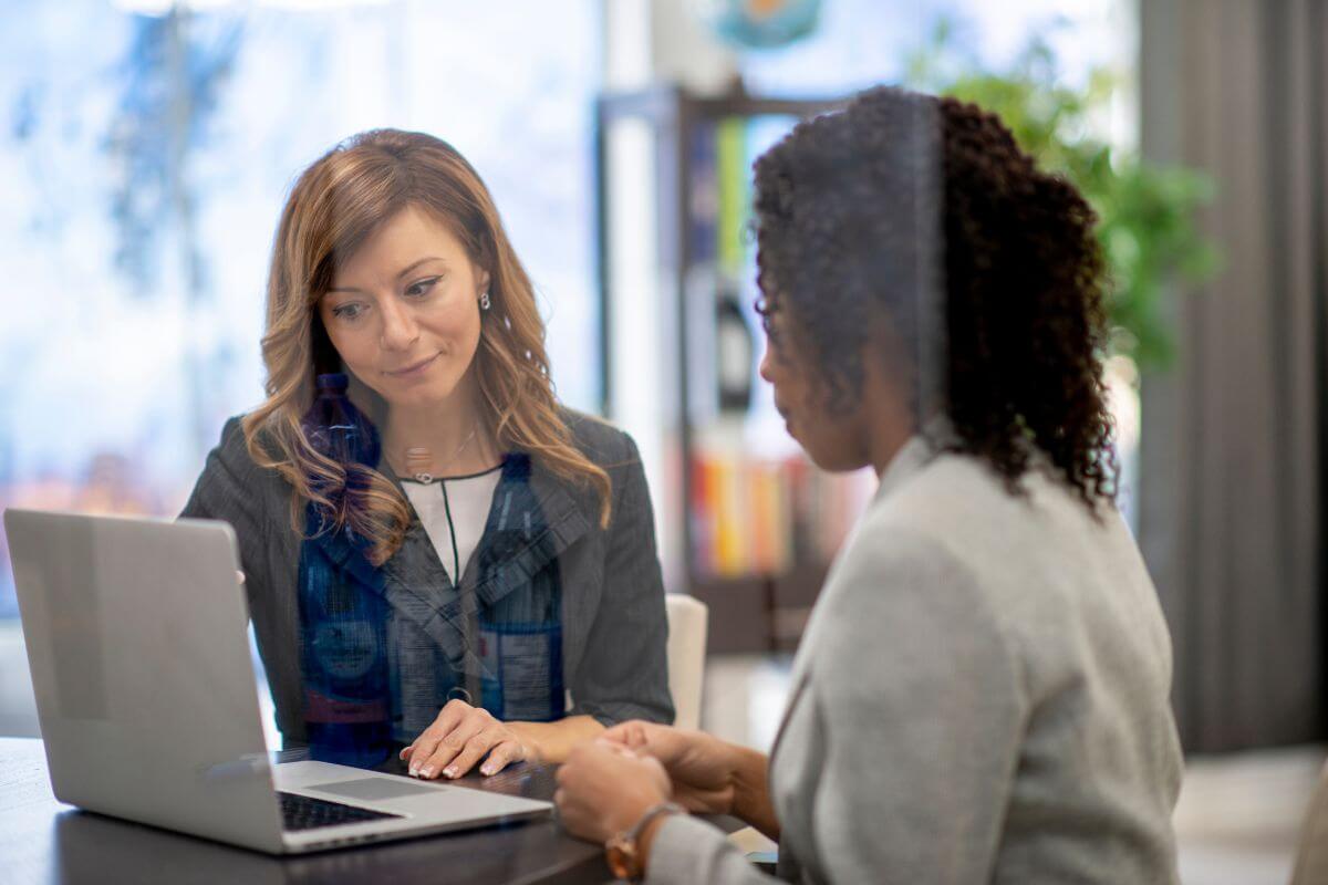 The photo shows two girls looking at a laptop which means participating in lucrative consulting is a way to earn extra income without a full-time commitment.