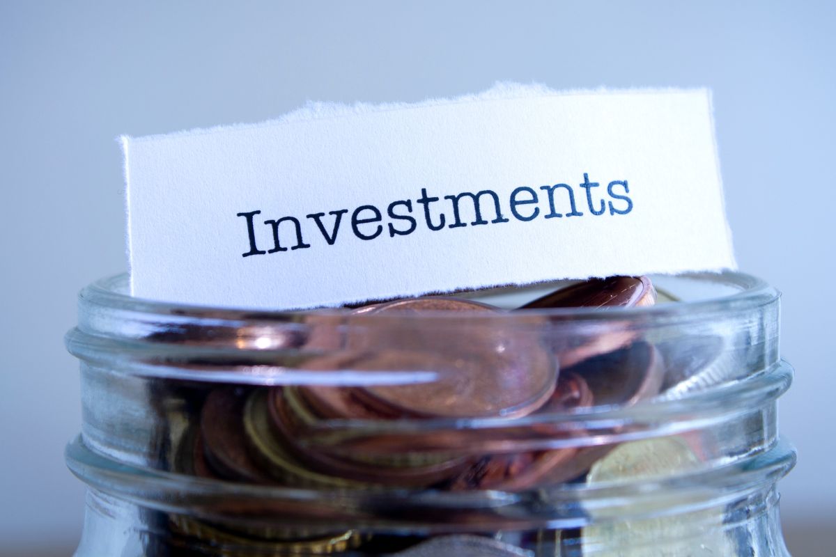 Photo of a jar with coins and investment note.