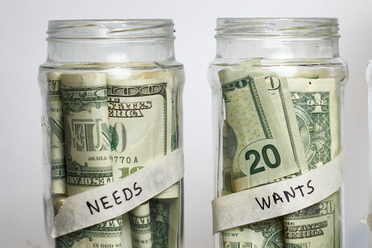 The image tells about jars with dollar bills inside with notes referring to failing to separate wants from needs is fastest ways to overspend.