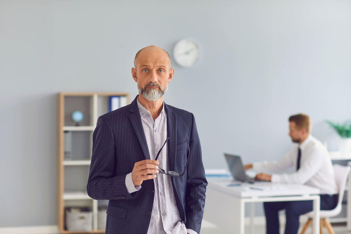 The image of a young employee working behind and an old man in a suit holding an eyeglass means retirees no longer need to worry about work-related membership fees which helps lighten your financial load.