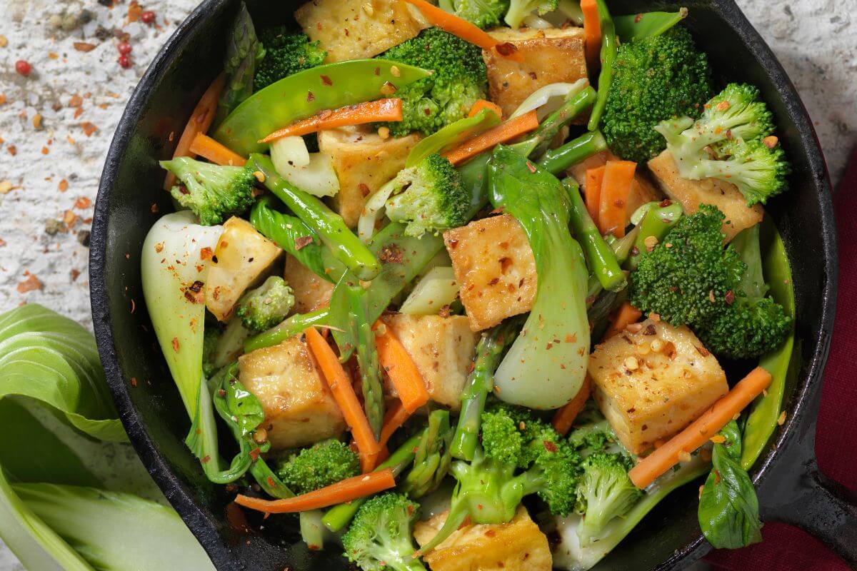 The image tells about a bowl with vegetable stir-fry which a frugal meal that's both tasty and nutritious.