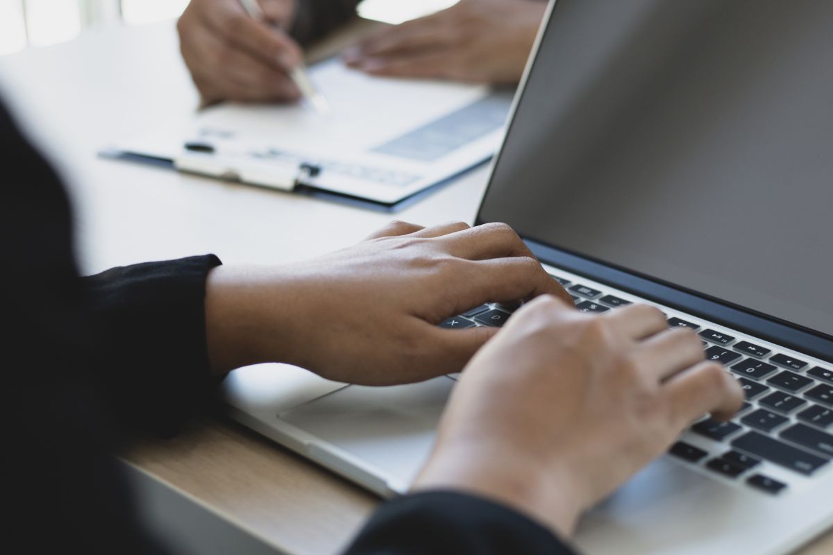 Image of a woman's hand using a laptop.
