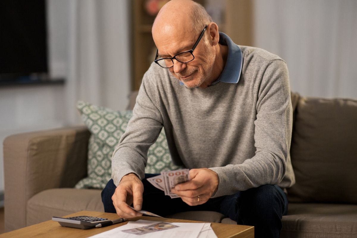Picture of a senior man counting money.