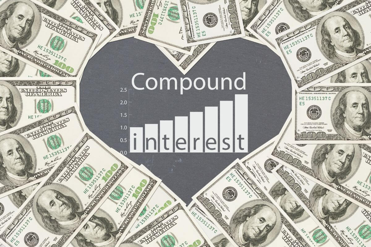 The photo shows dollar bills shaped with a heart with numbers, a graph, and notes referring to educating yourself about compound interest and its benefits can turn into big savings if left to grow.