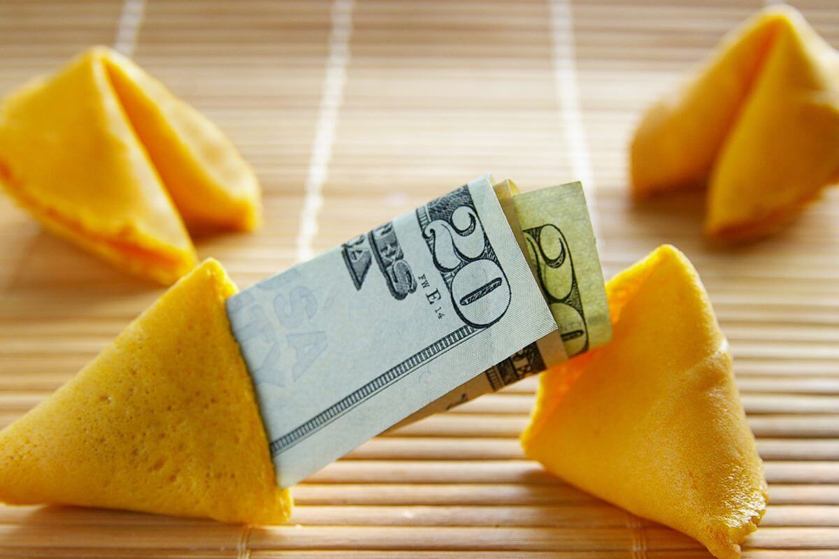 The picture tells about fortune cookies and a dollar bill referring to the focus on eliminating limiting beliefs about money and replacing them with positive beliefs that build confidence and support financial growth.