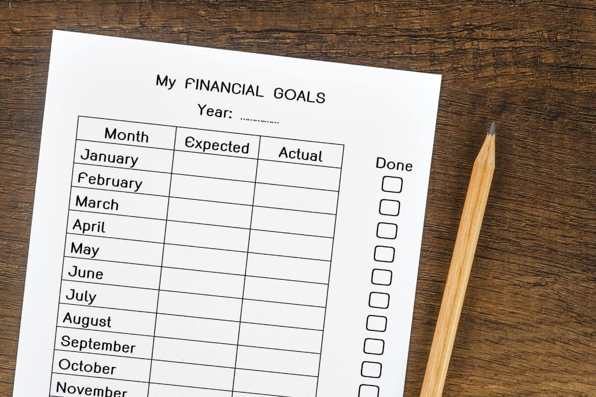 The picture tells about a pen and a piece of paper with notes indicating that setting clear financial goals and timelines keeps you focused and makes manifesting wealth more actionable.