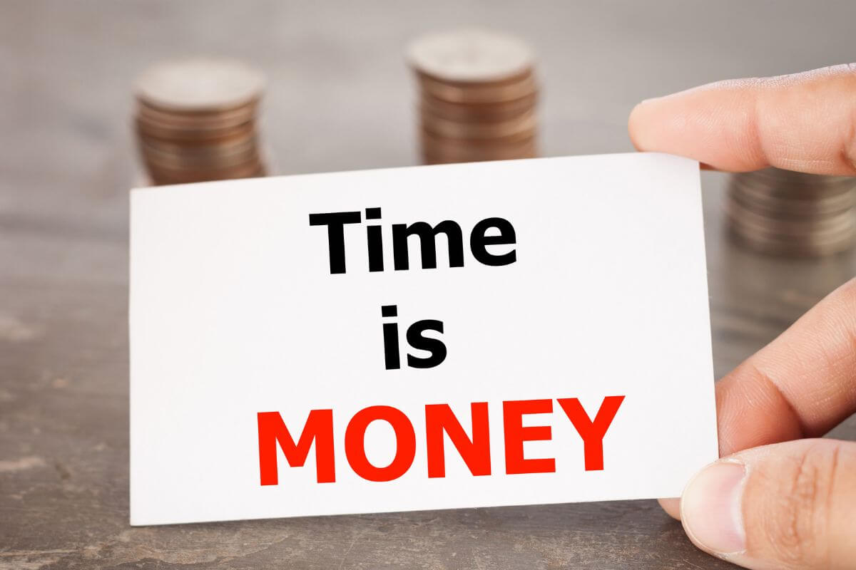 The picture tells about coin stocks and a man's hand holding a piece of paper with notes indicating to pick your money mantra to repeat helps reinforce confidence and focus on your money goals.