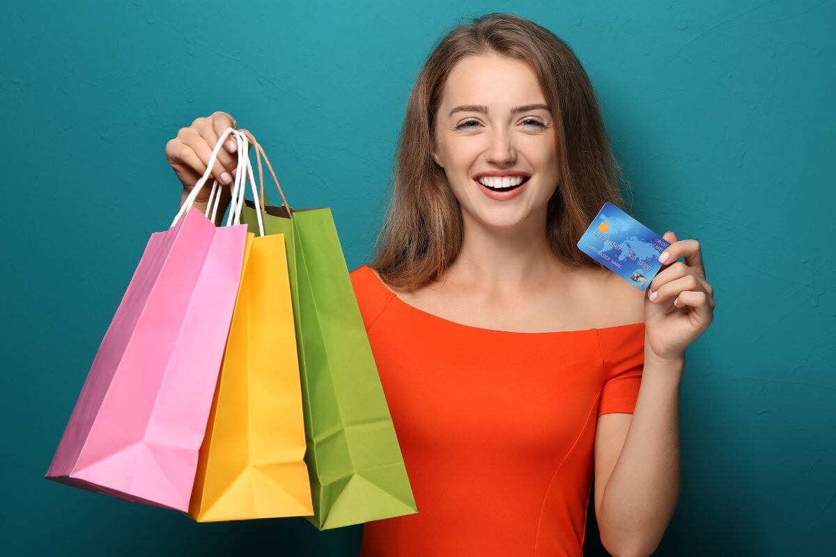 The photo tell about a girl carrying shopping bags while showing the credit card which means bad debt is used to buy things that lose value quickly and don't provide any future return.