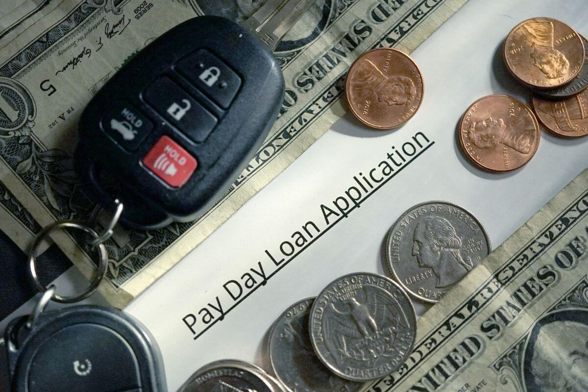 The picture shows coins, dollar bills, a remote key, and a apiece of paper with notes indicating that one of the examples of bad debt is payday loans which often create financial stress and keep you stuck in a cycle of payments.