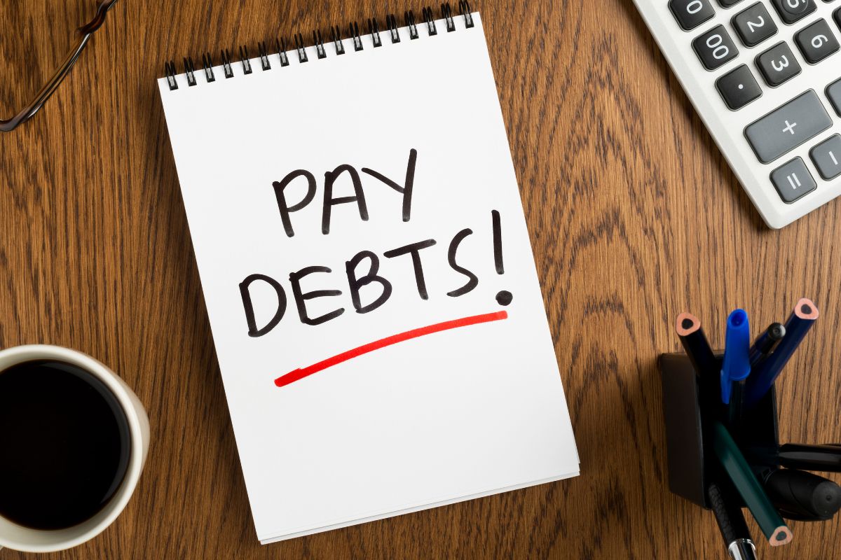 Picture of a notebook with pay debt wording.