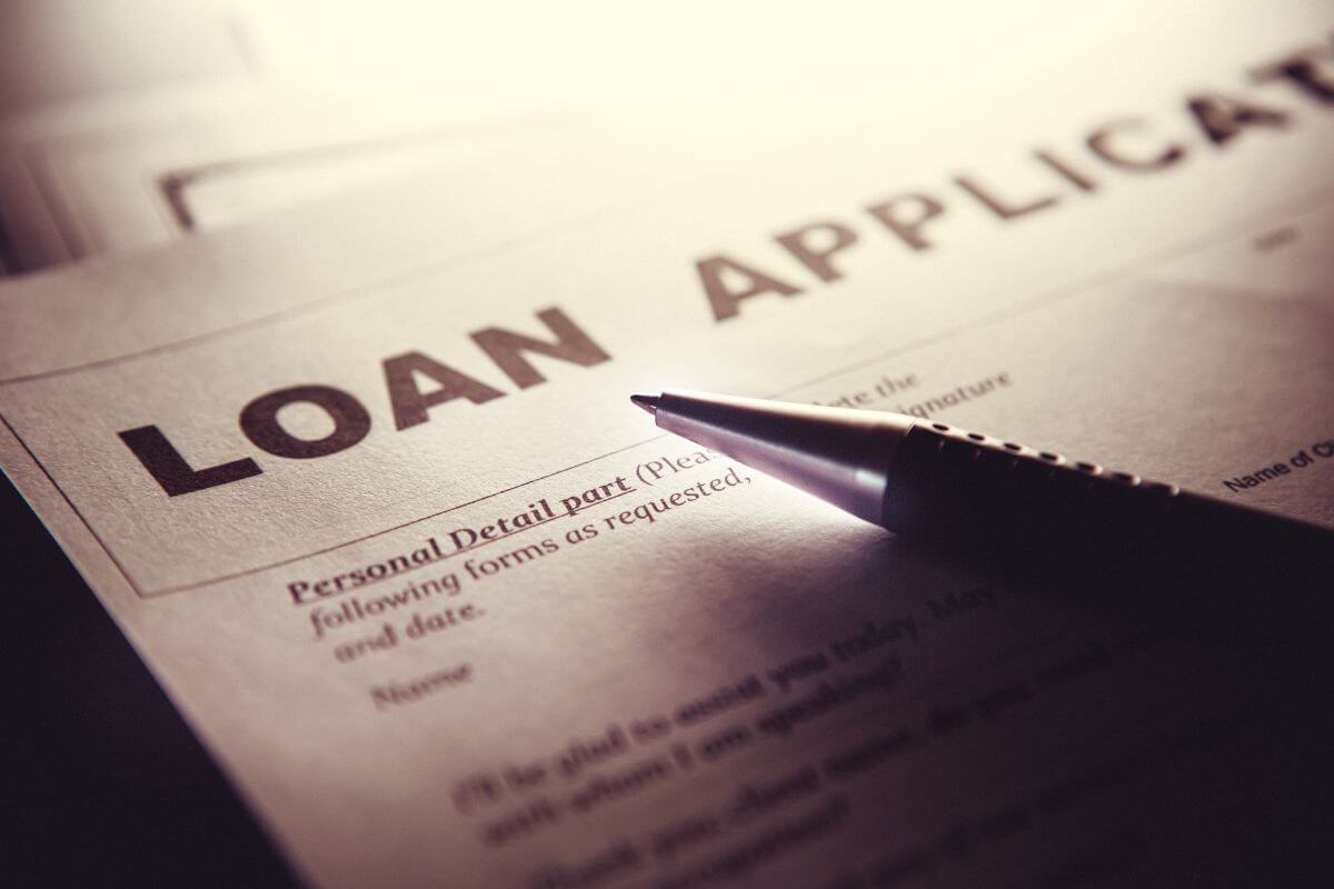 The picture tells about a pen and a piece of paper with notes indicating that avoiding taking on any debt, should always have a purpose tied to improving your financial outlook.