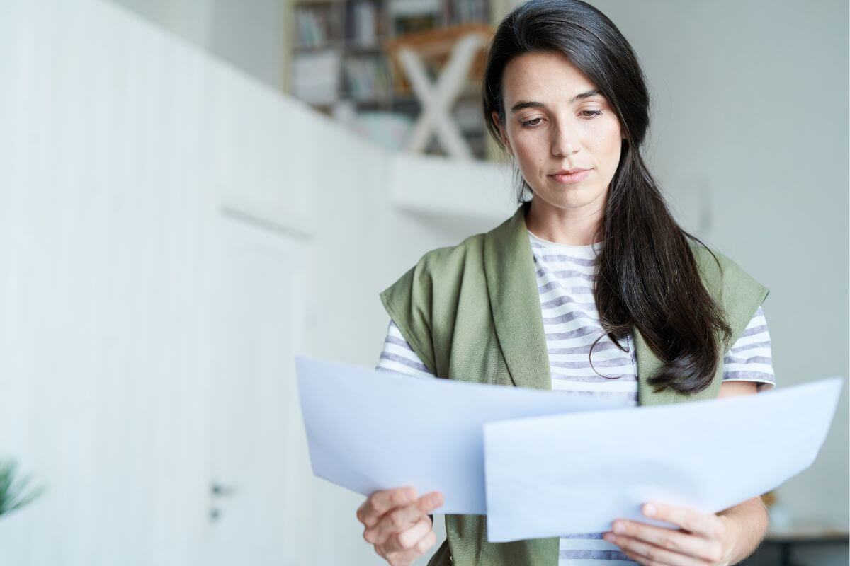 The picture tells about a girl looking at the papers which means to always understand the full cost of borrowing before taking on debt protects your financial future.