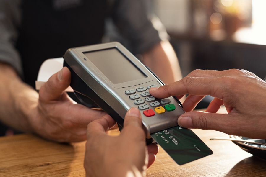 Photo of a man's hand paying credit card.