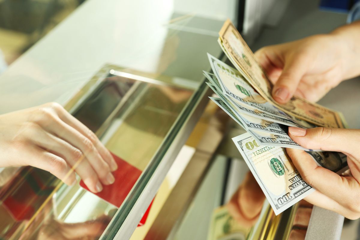 The image shows a woman's hand paying for her order.