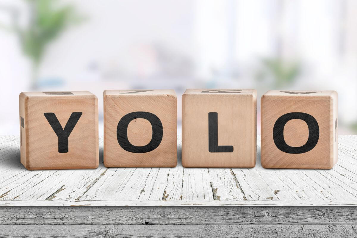 The photo tells about wooden cubes with letters referring to YOLO doesn't apply to draining your savings and protecting your savings can enjoy life without financial strain later on.