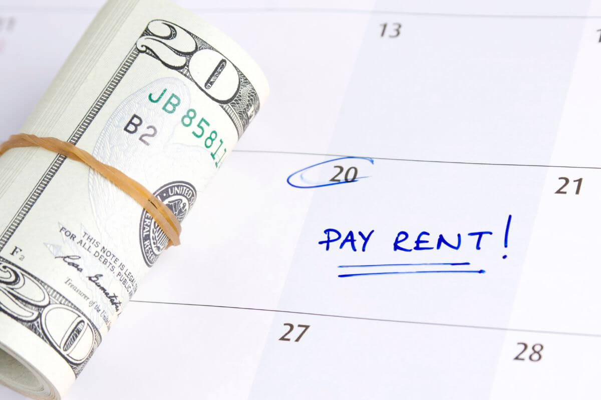 The picture tells about rolled dollar bills and a calendar with notes indicating to rent money is more important than Netflix subscriptions to stay financially stable and a void debt. 