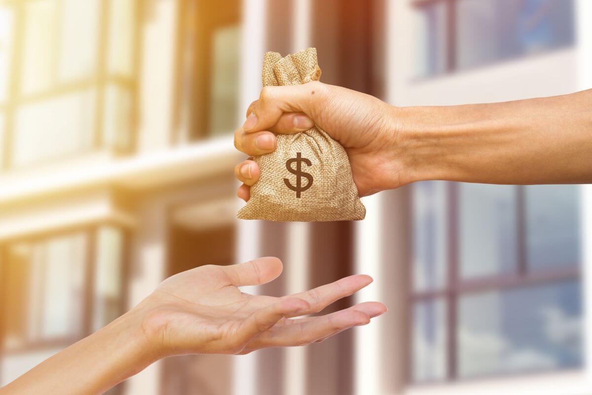 The photo tells about a man's hand giving a small bag of money to the girl's hand which means to stop lending money to people who never pay you back which puts your finances at risk.