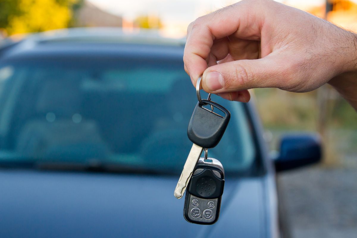 Picture of a man's hand holding a car key.