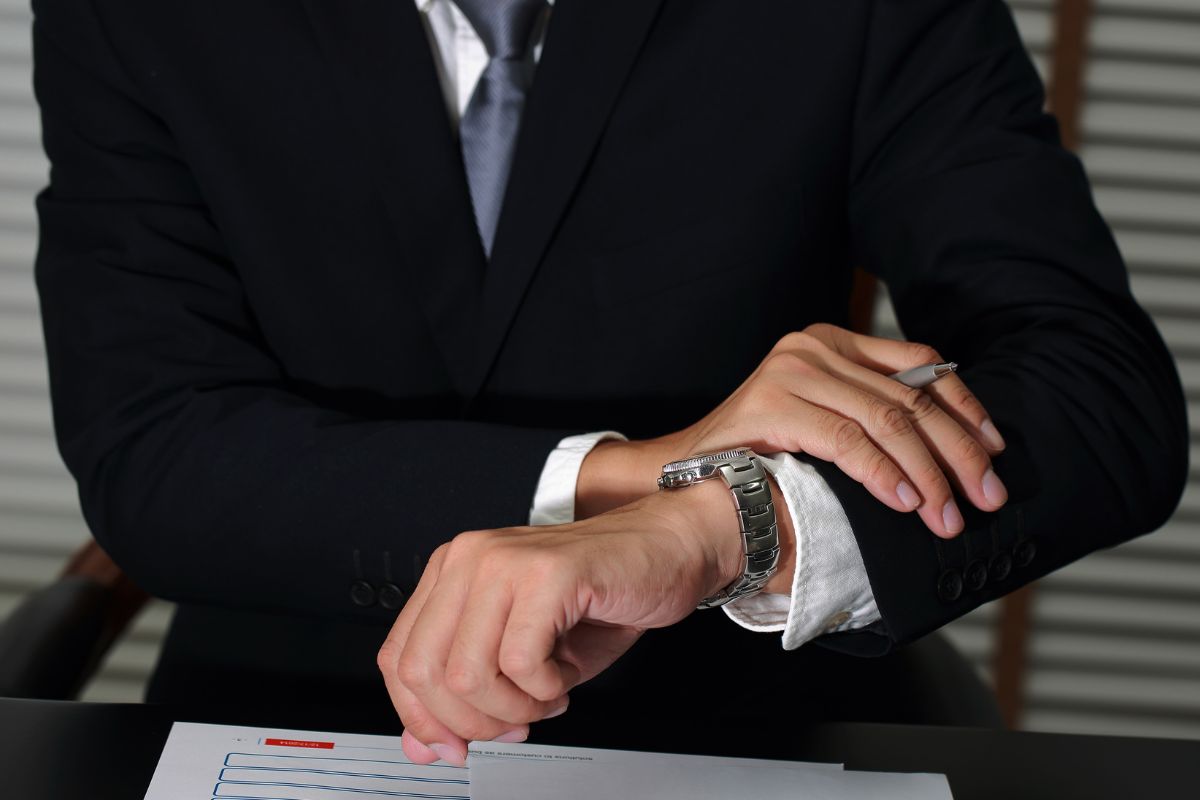 Image of a man checking his watch.