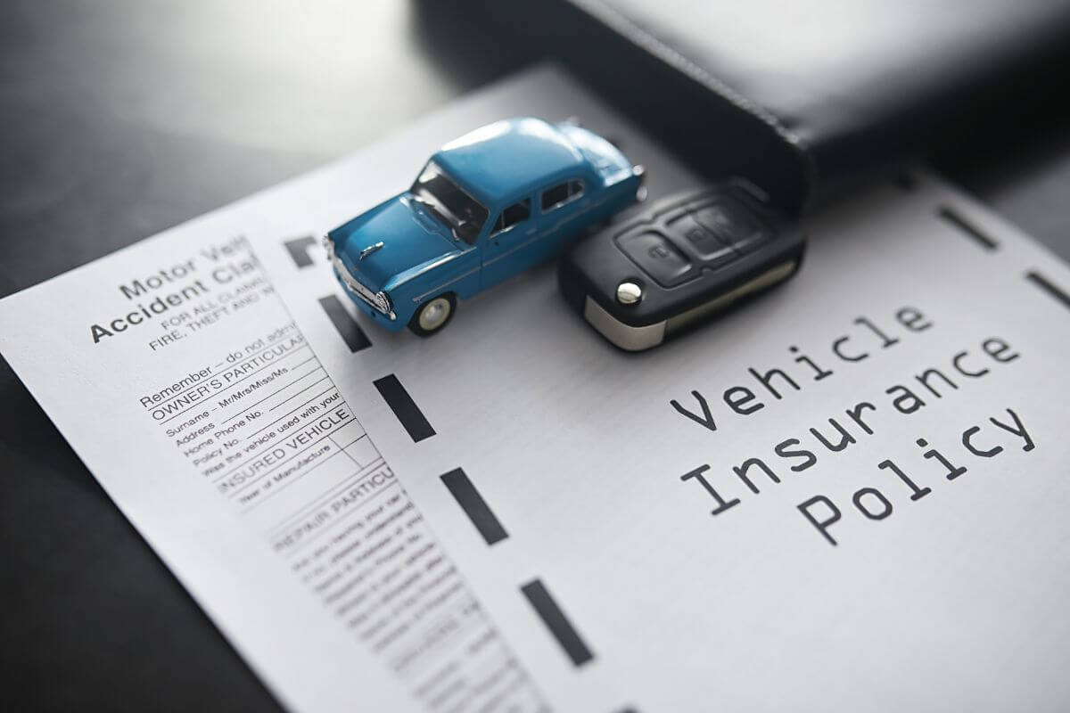 The image of a notebook, a toy car, a remote key, and papers with notes referring to retirees often reduced vehicle insurance rates and made car ownership more affordable in retirement.