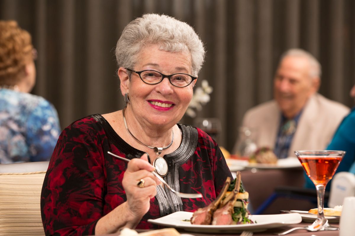 Image of a senior woman eating at a restaurant.