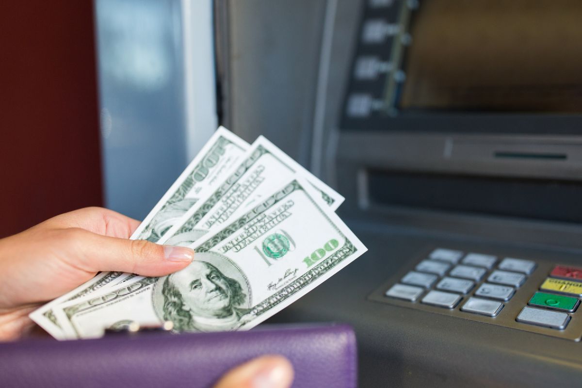 A woman's hand withdrawing cash.