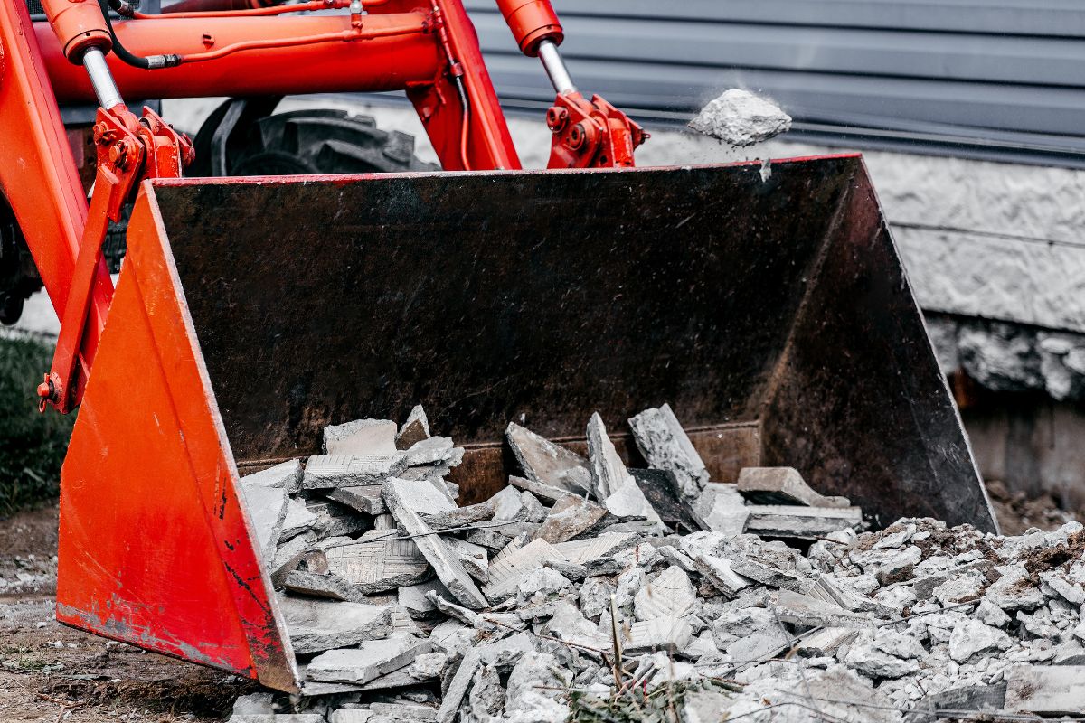 Photo of bucket tractor with debris.