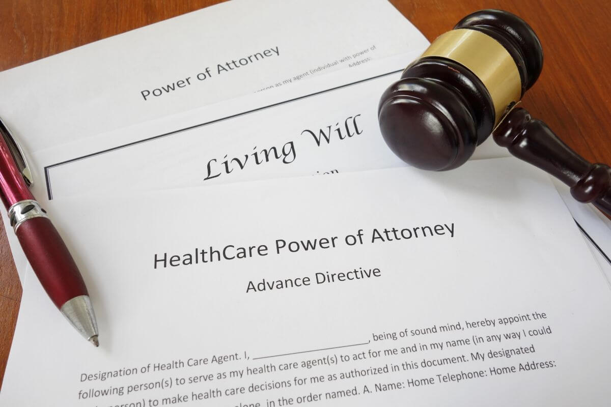 The picture tells about papers with notes, a pen, and a gavel on the table referring to ignoring the need for a healthcare power of attorney leaving you unable to make decisions.