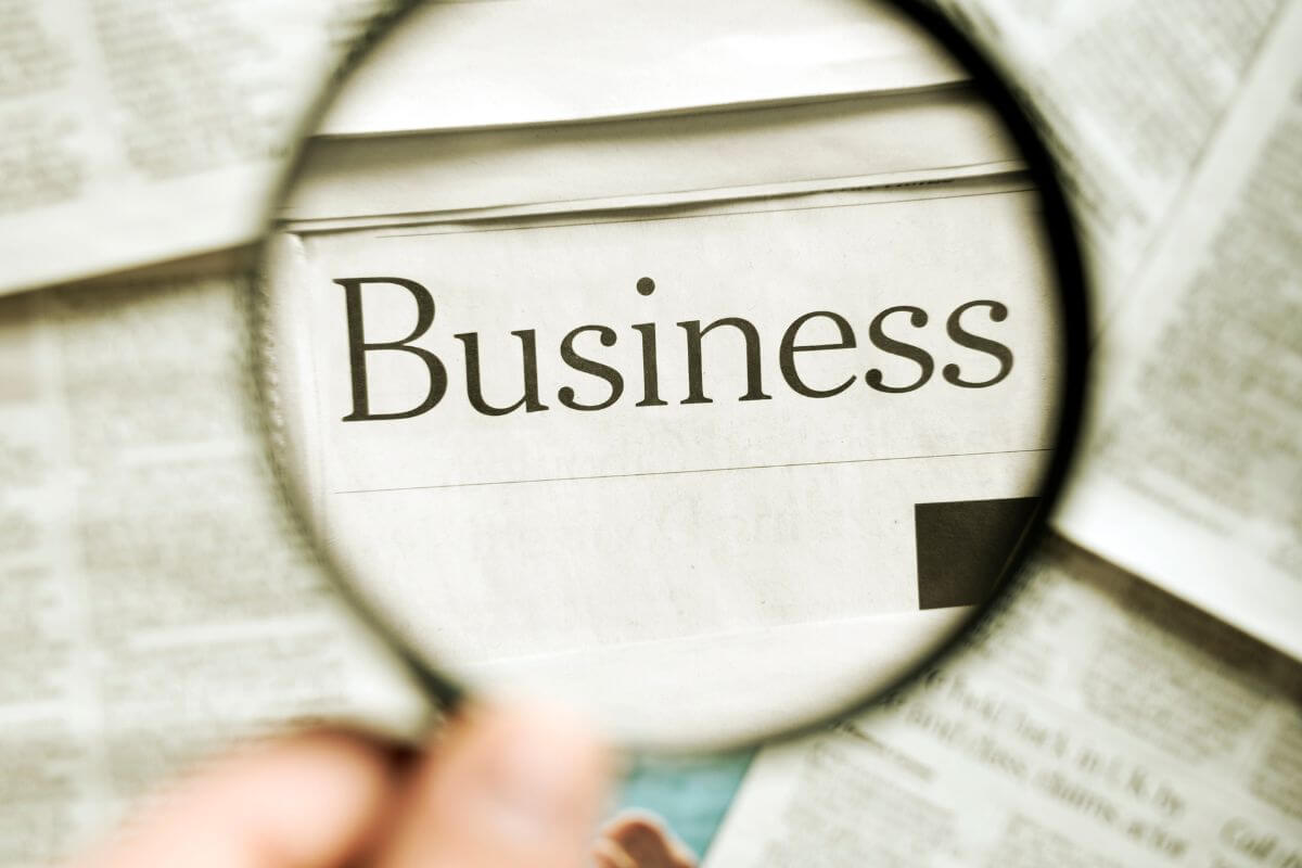 The picture tells about papers with notes, and a girl's hand holding a magnifying glass focusing on certain work referring to failing to provide clear instructions for business succession can cause it to collapse, a clear succession plan ensures your hark word continues after you are gone.