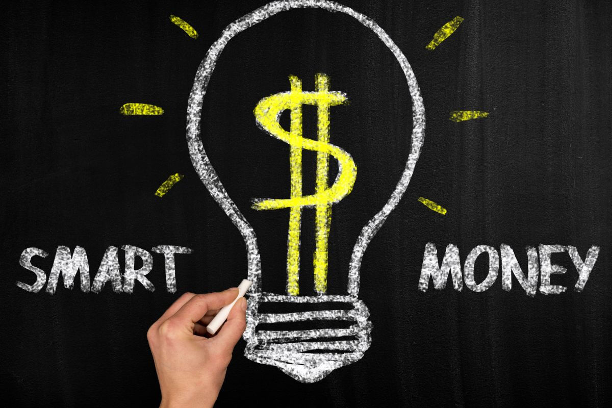 The picture tells about a girl's hand drawing and writing on a blackboard which means to start making smart money moves can make unexpected events less overwhelming and help you focus on what matters most.
