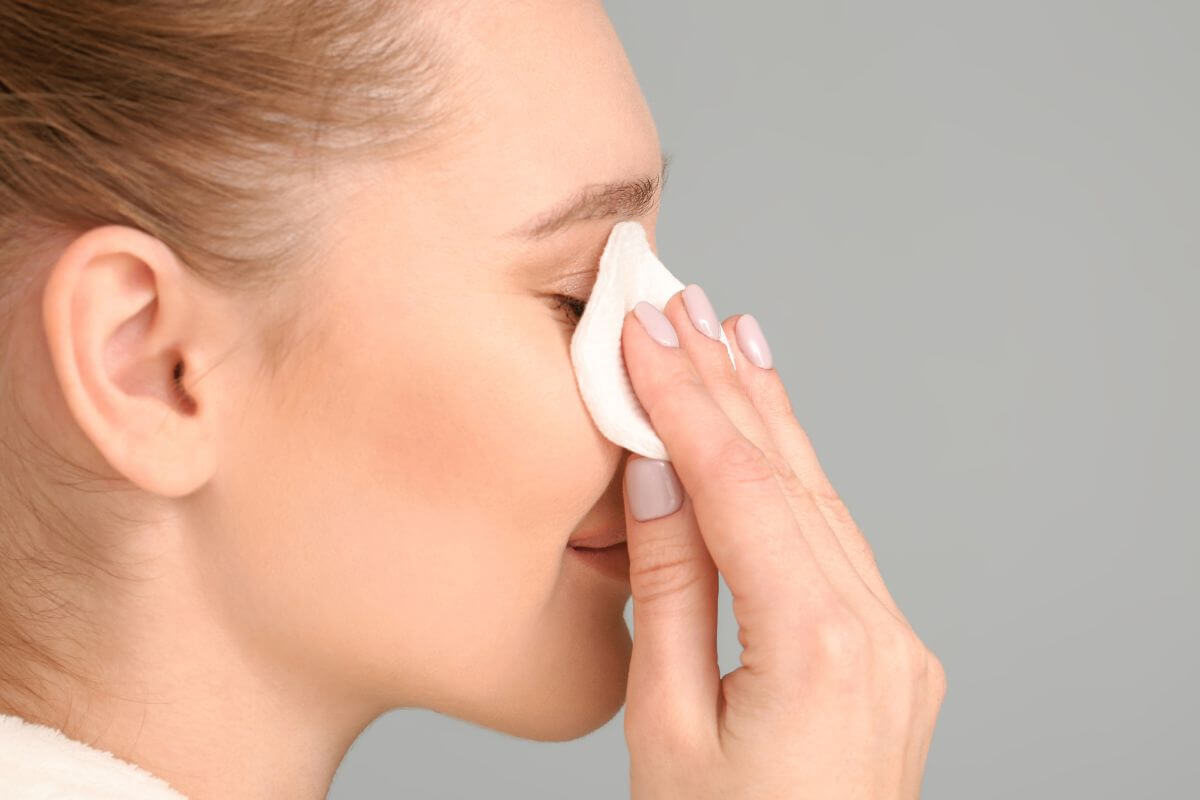 The image tells about a girl cleaning her face with disposable makeup wipes are a recurring expense that can be replaced with reusable clothes or pads.