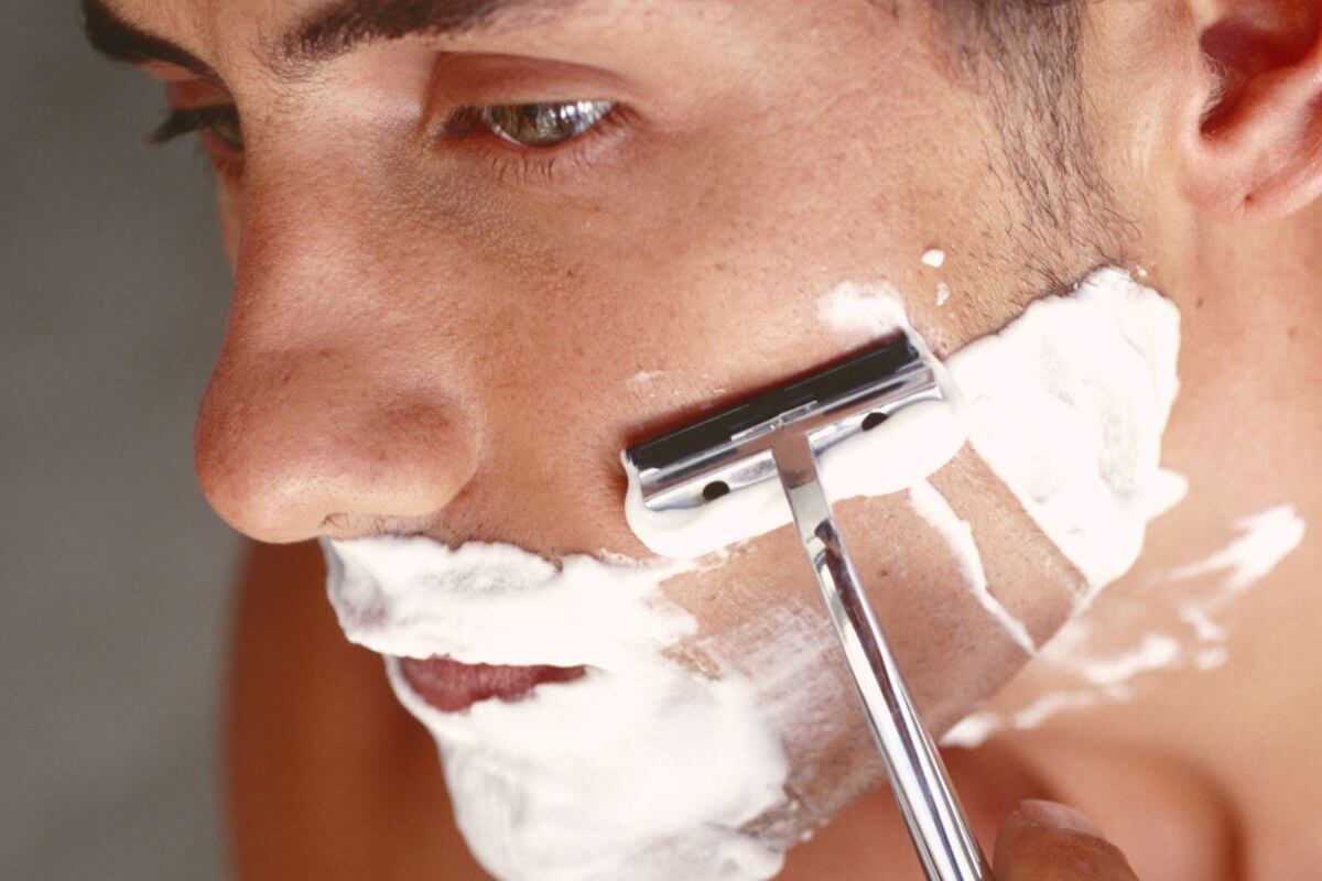 The picture of a man trimming his beard using a shaving cream can often replaced with more affordable alternatives like soap or conditioner.