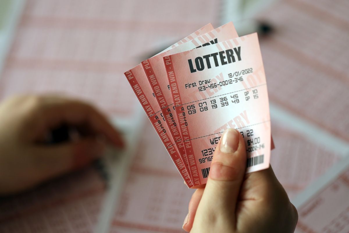 Picture of a woman's hand holding lottery tickets.