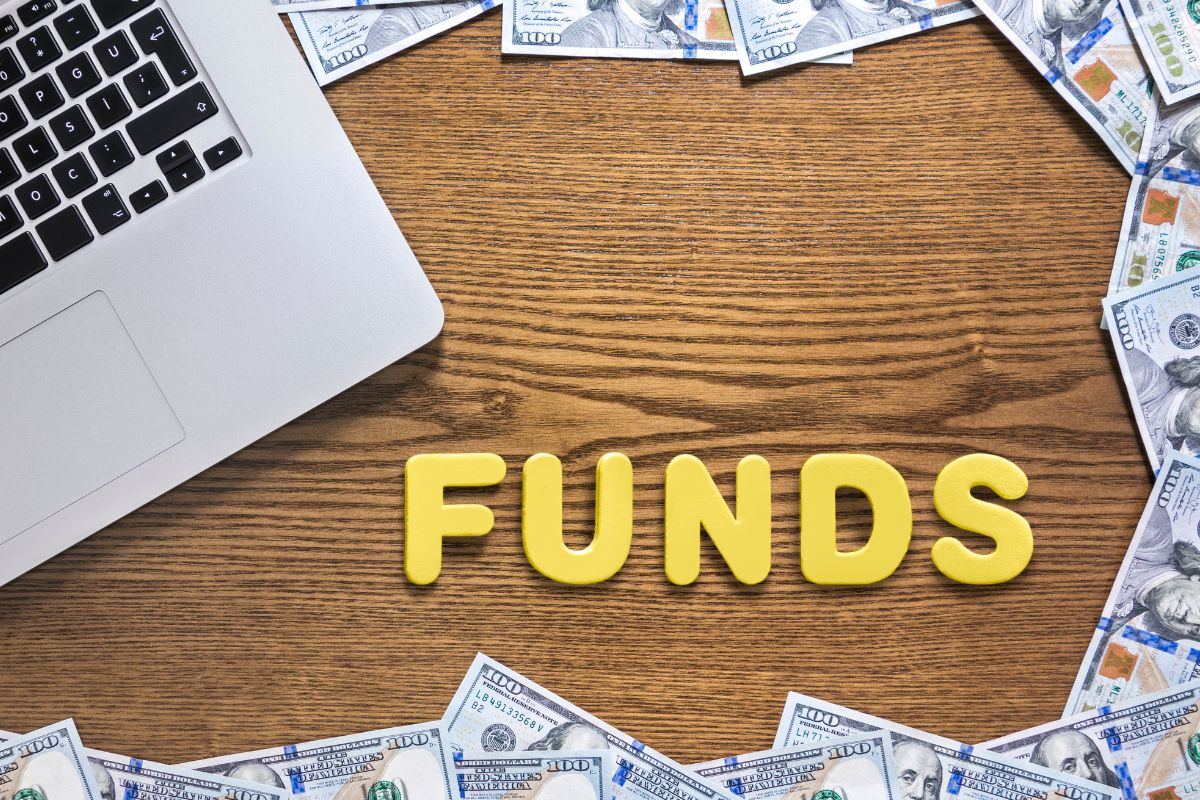 Picture of a laptop, money, and fund wording.
