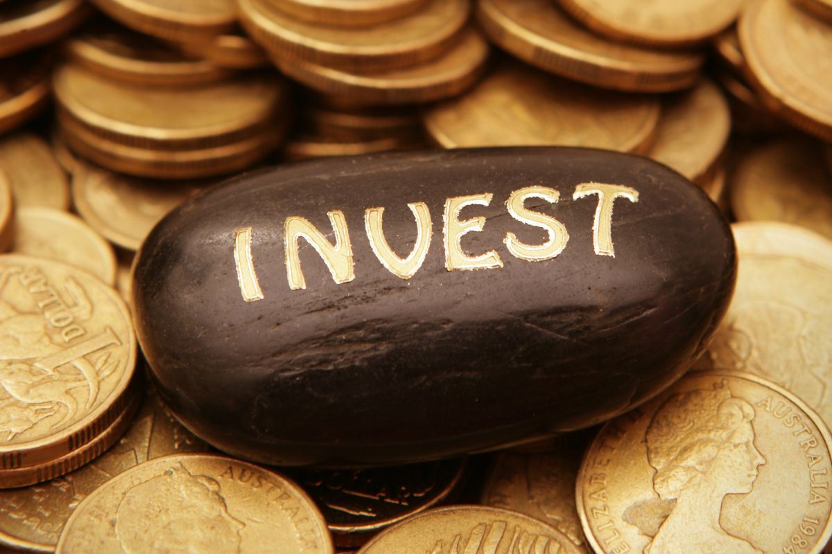 Picture of coins and invest wording.