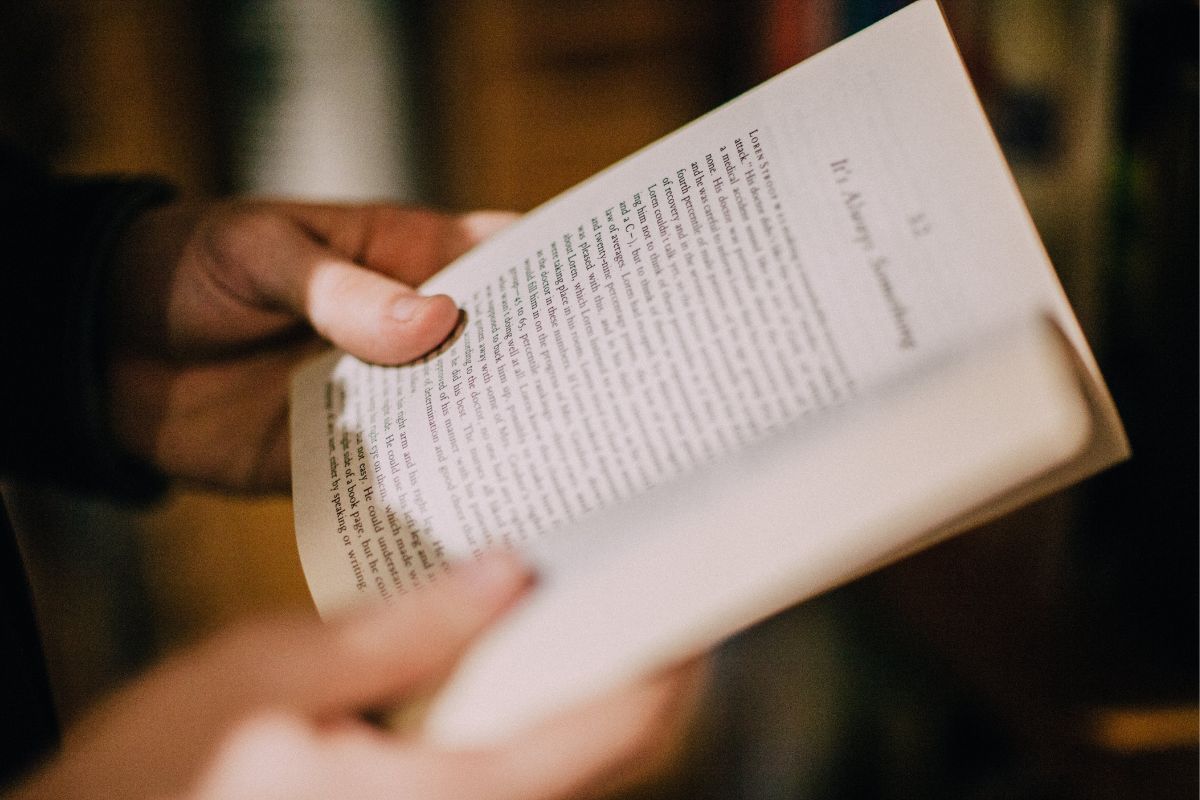 Picture of a woman's hand reading a book.