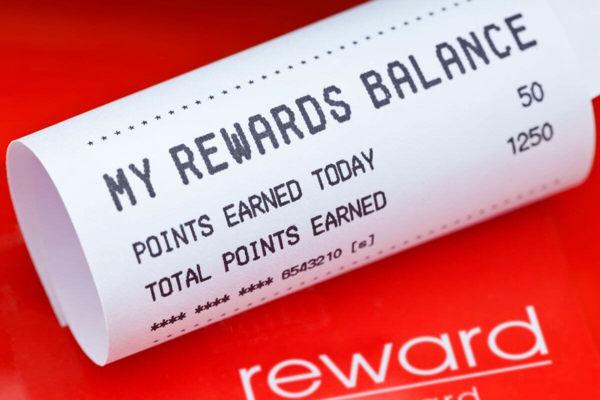 The picture of a piece of paper with notes and a red paper with a note which means rewards programs for debt cards let you make the most of your money while staying financially safe.