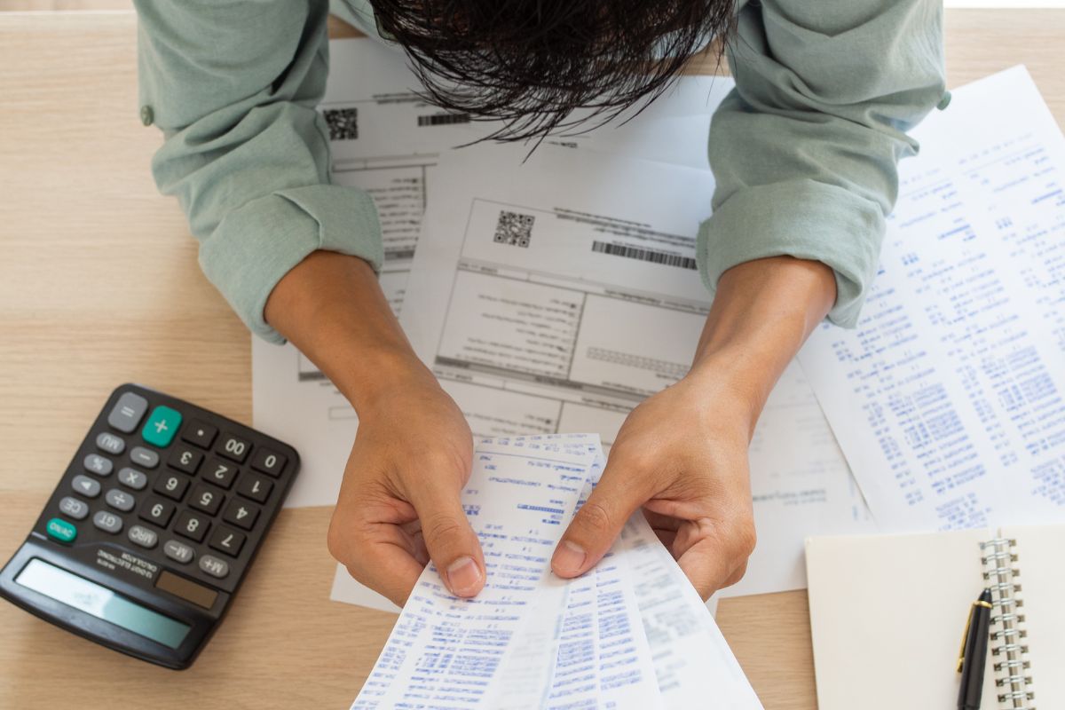 The picture shows a man reviewing his expenses.