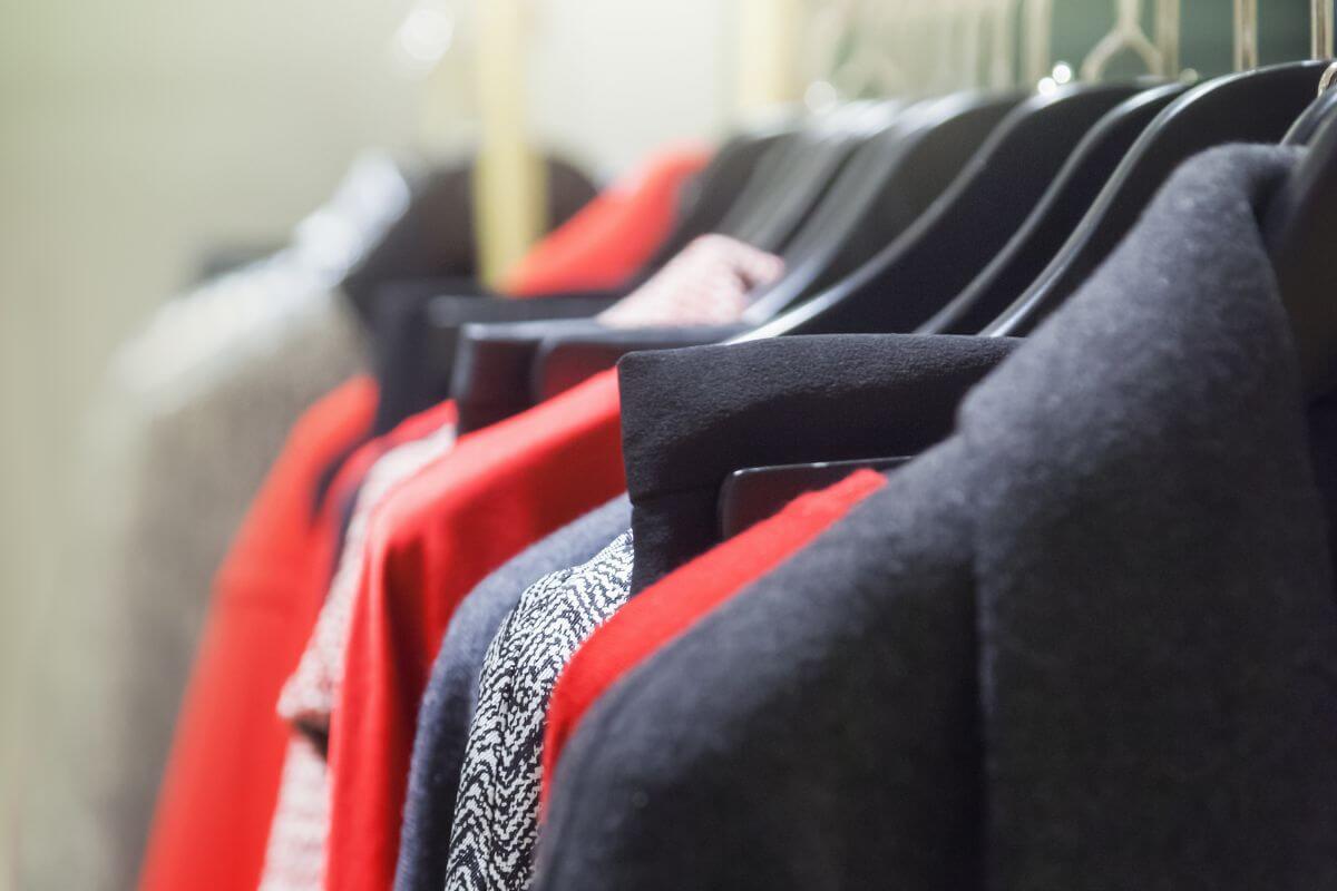 The image tells about clothes on the rack referring to decluttering clothes you haven't worn in a year and donating or selling them.