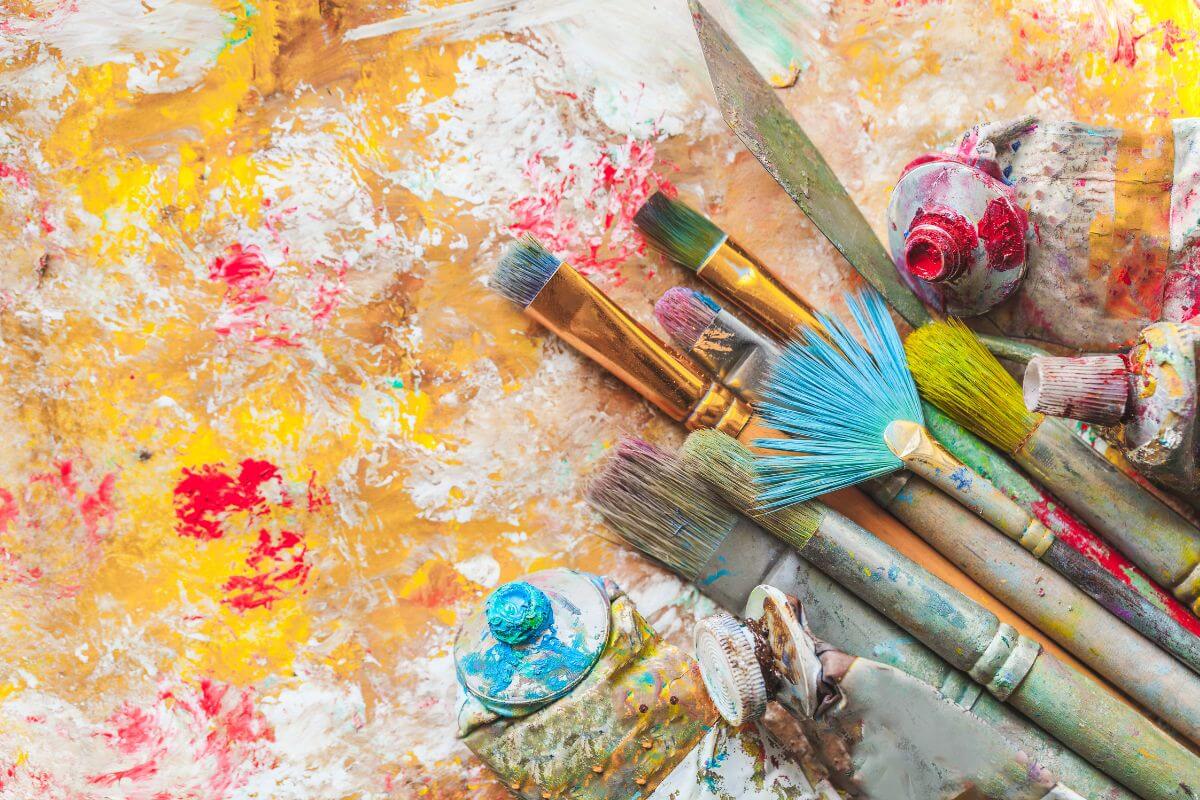 The photo tells about uncleaned brushed, color paints, and dirty canvas referring to unused hobby supplies that no longer often sit unused and take up space, donate or sell them to simplify your storage.