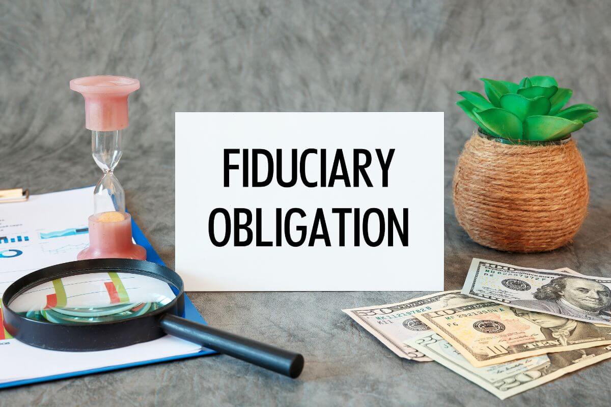 The image tells about a plant, dollar bills, on the table, a glass hour, a magnifying glass, a clipboard, and a piece of paper with notes referring to asking if an advisor is a fiduciary and what that means for your advice helps you understand their legal obligation to act in your best interest.