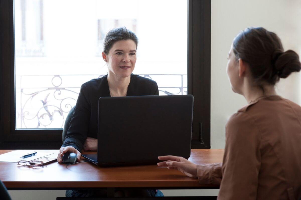 The image shows a client and an advisor talking together referring to asking your advisor about conflicts of interest helps you uncover whether an advisor may prioritize their gain over your financial goals.