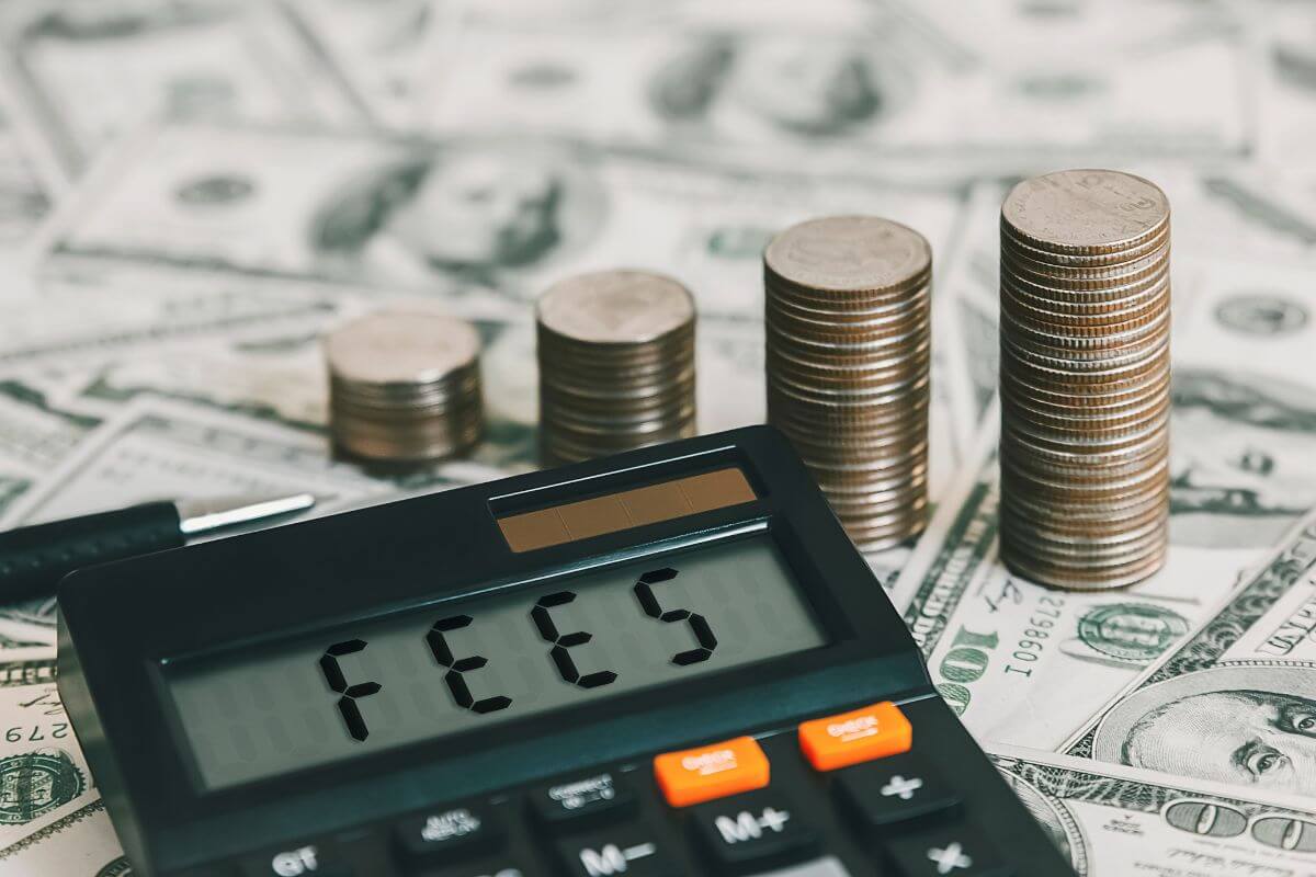 The picture shows dollar bills, coin stocks, a pen, and a calculator with a note which means an advisor should provide a clear explanation of all fees and costs involved so you know exactly what you're paying for.