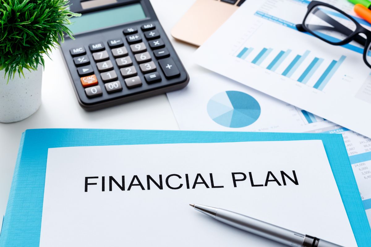 Photo of a calculator and a paper with financial plan wording.